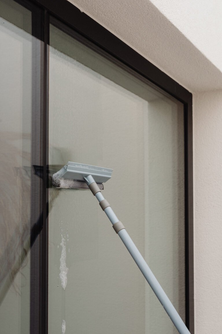 Fensterwischer bei der Reinigung einer großen Glasscheibe